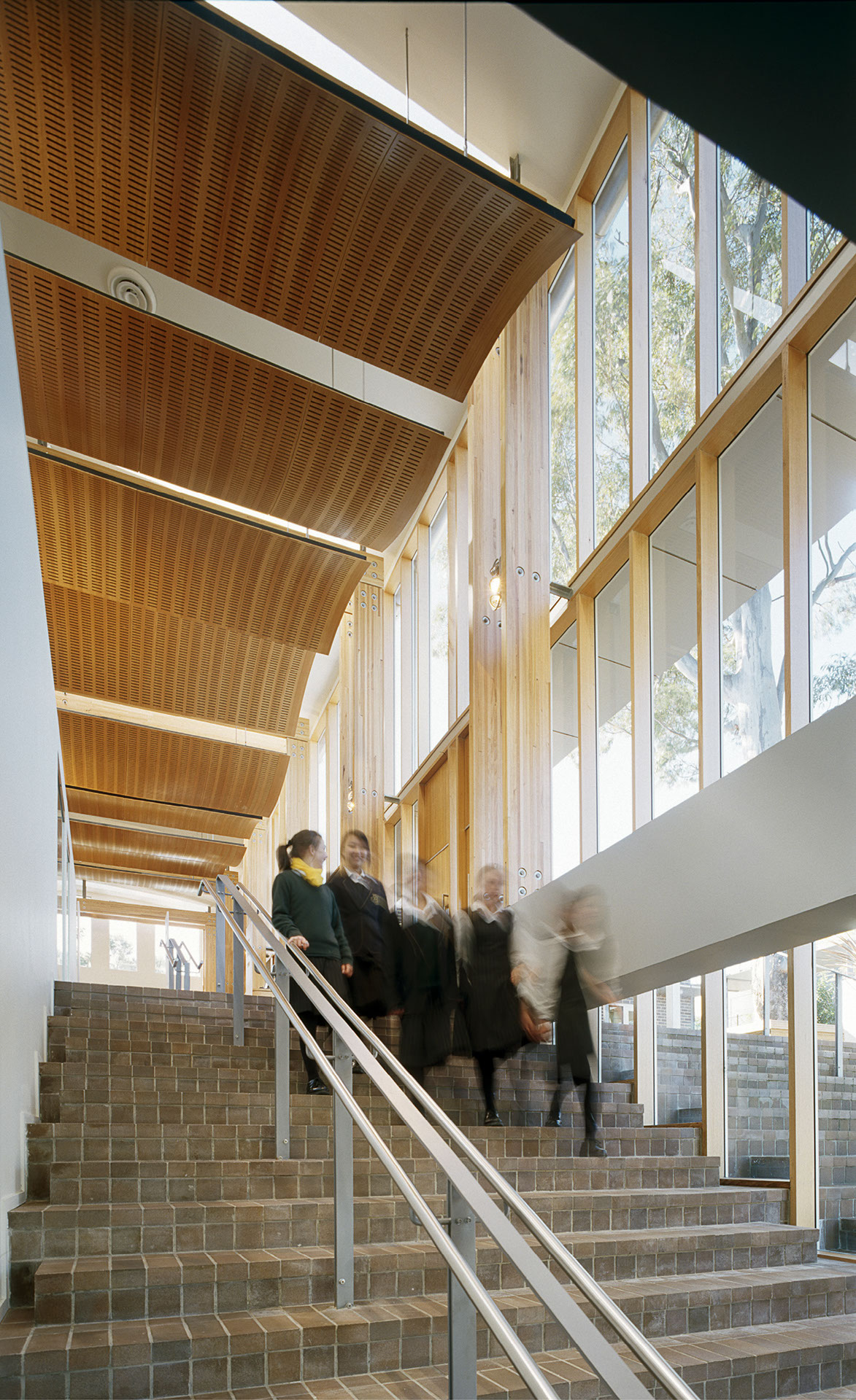 Interior view of Abbotsleigh Research Centre showing students walking downstairs with a wooden ceiling.