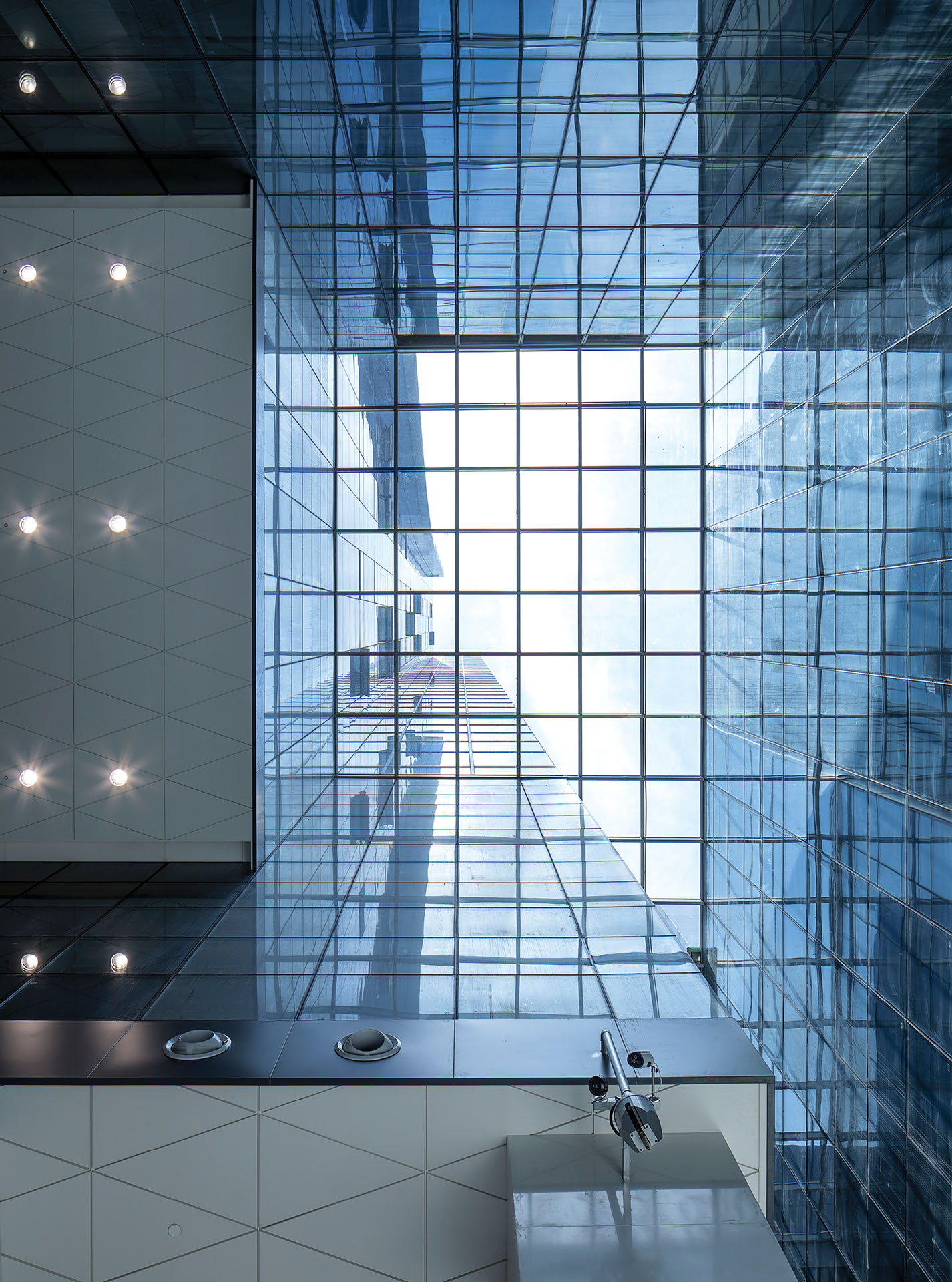 Interior view of China Mobile Global Telecommunications Centre looking up to the sky through the glass ceiling.